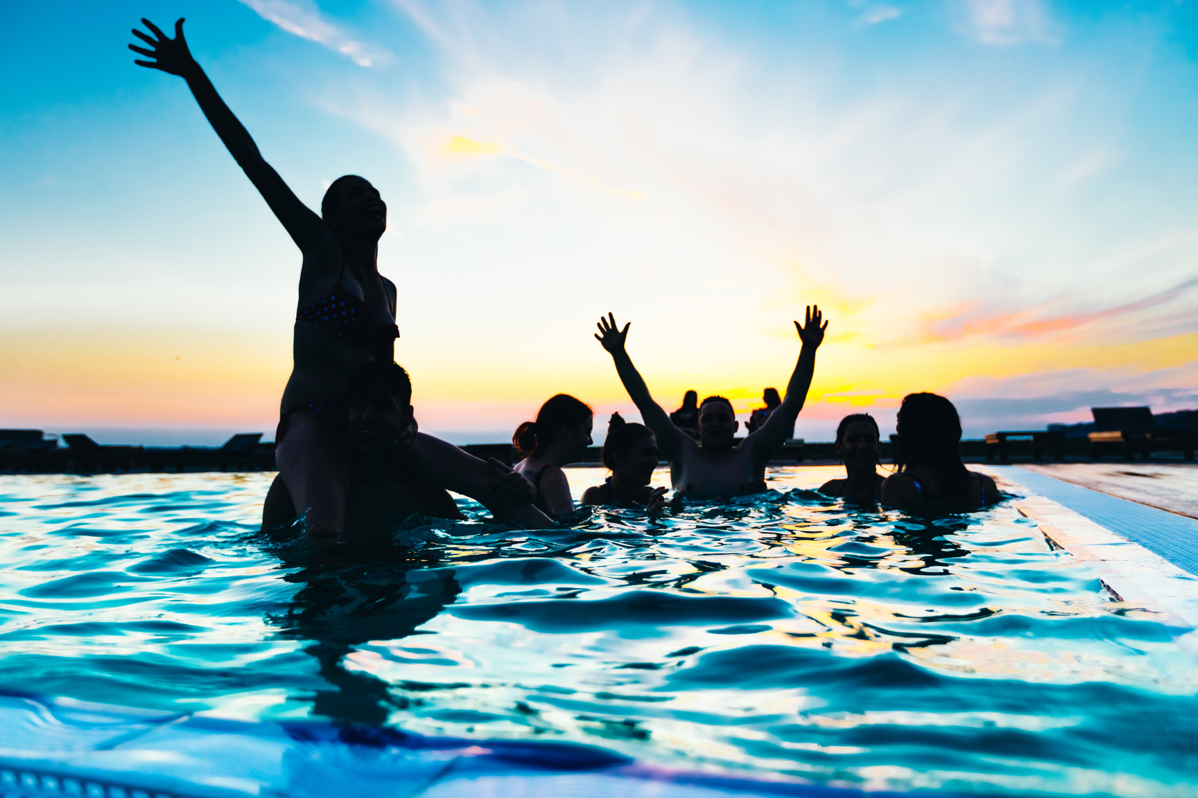 Friends enjoying a sunset pool party