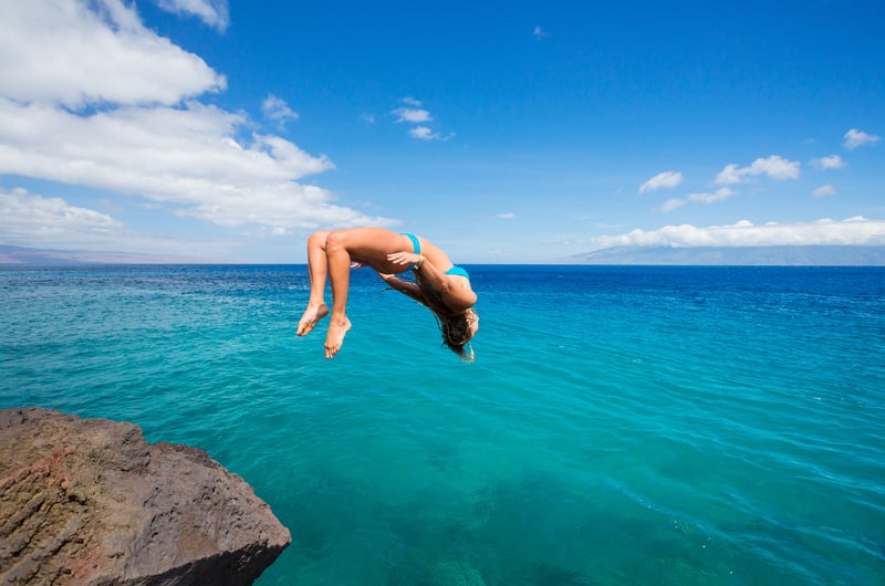 Woman Doing Back-flip into Ocean